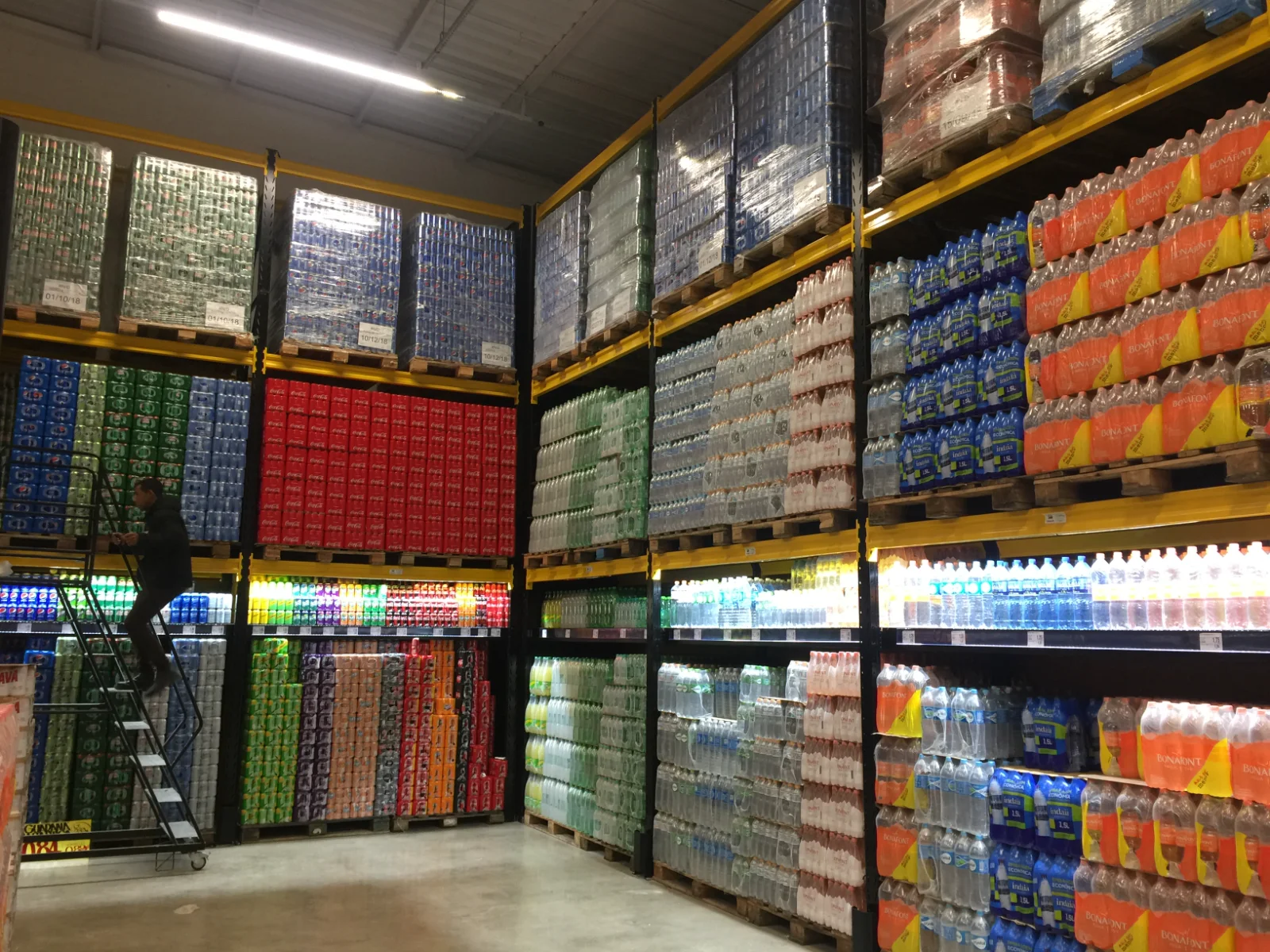 Corredor de perfumaria com paletes na retaguarda superior